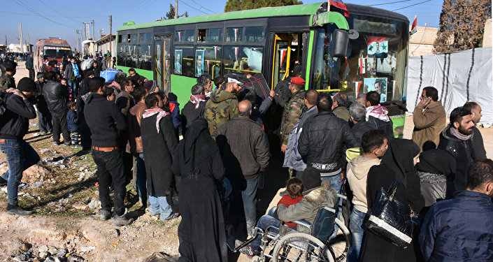 Сиријци који напуштају Алеп улазе у аутобус у селу Азиза