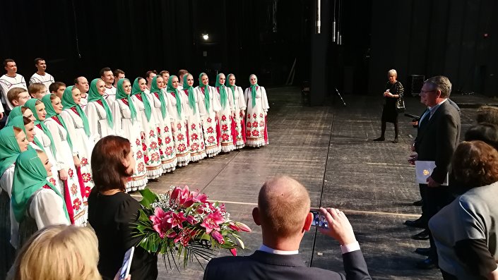 Амбасадор Русије Александар Чепурин уручује хору „Митрофан Пјатницки“ писмо захвалности и цвеће