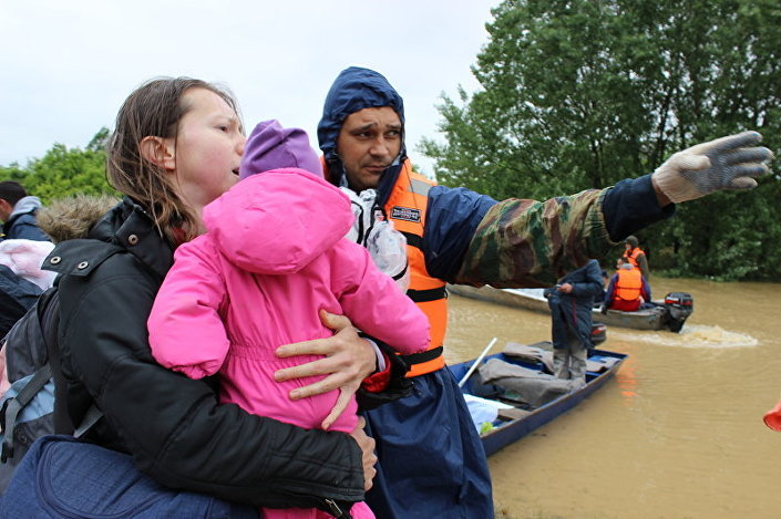 Коначно на сигурном - спасилац из Русије показује унесрећенима пут за евакуацију из поплављеног подручја.