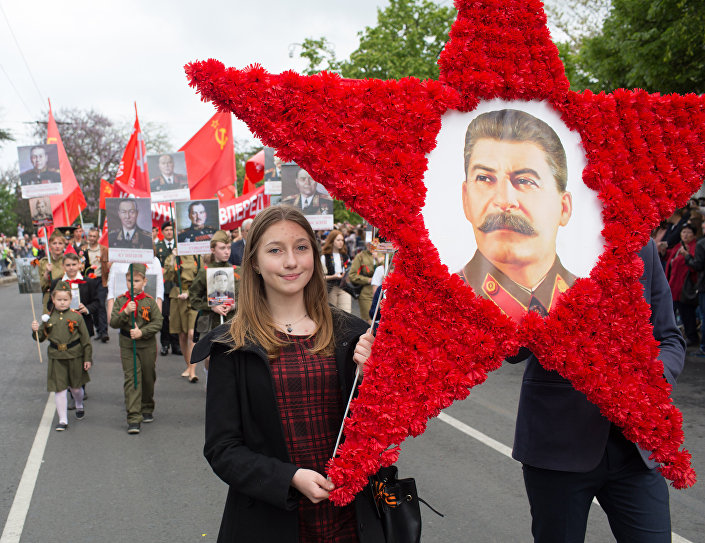 Девојка носи слику Јосифа Стаљина на дан акције Бесмртни пук