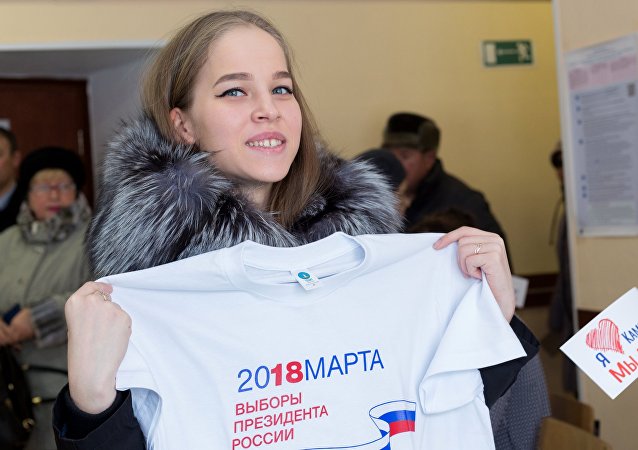 Девојка показује мајицу на председничким изборима у Русији